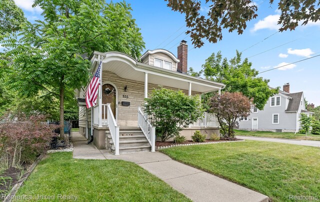 535 S Edison Ave, Royal Oak, MI 48067 - view of front facade with a porch, a chimney, a front yard, a gate, and stone siding
