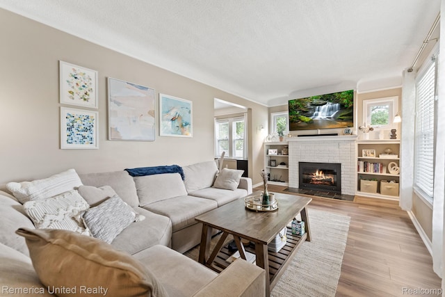 535 S Edison Ave, Royal Oak, MI 48067 - living area with a brick fireplace, light wood-style flooring, healthy amount of natural light, and a textured ceiling