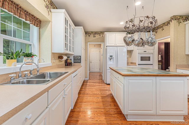 6155 Carey Rd, Commerce Twp, MI 48382 - kitchen with white appliances, light wood-type flooring, a chandelier, white cabinets, and wallpapered walls