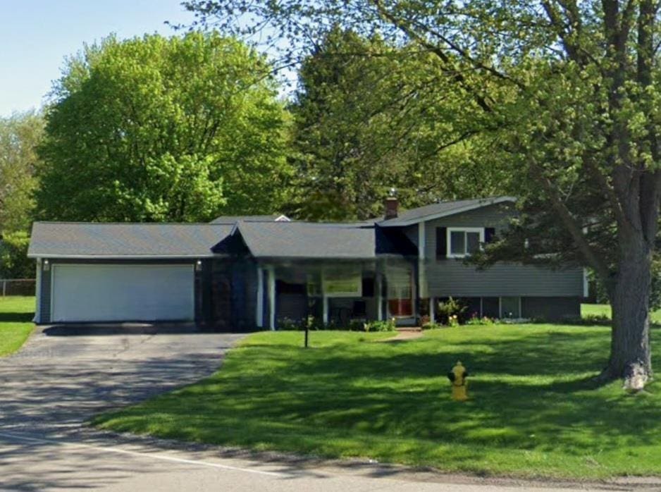 5252 Maple Rd, Swartz Creek, MI 48473 - tri-level home with driveway, an attached garage, and a front lawn