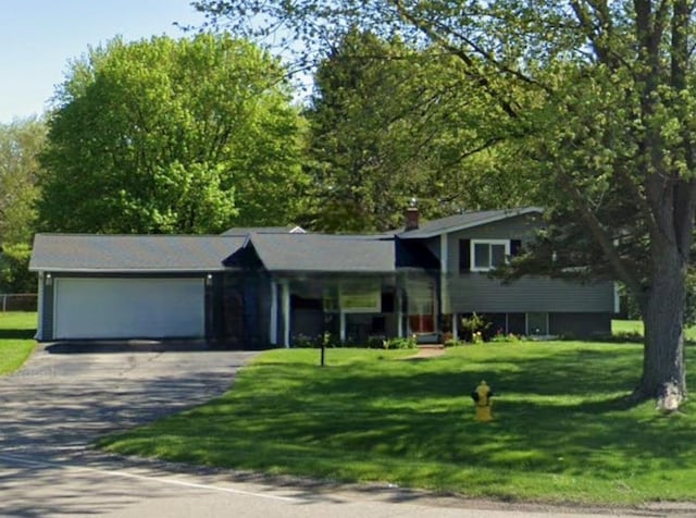 5252 Maple Rd, Swartz Creek, MI 48473 - tri-level home with driveway, an attached garage, and a front lawn