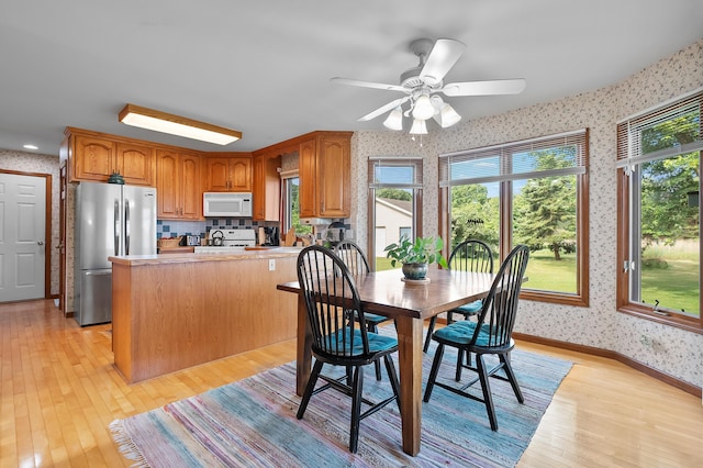 64670 Windrose Way, Lawton, MI 49065 - dining room featuring wallpapered walls, light wood finished floors, and ceiling fan