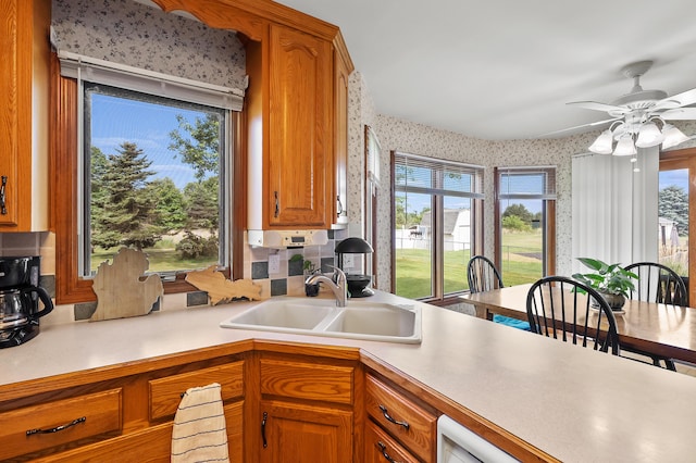 64670 Windrose Way, Lawton, MI 49065 - kitchen with wallpapered walls, light countertops, brown cabinetry, and ceiling fan