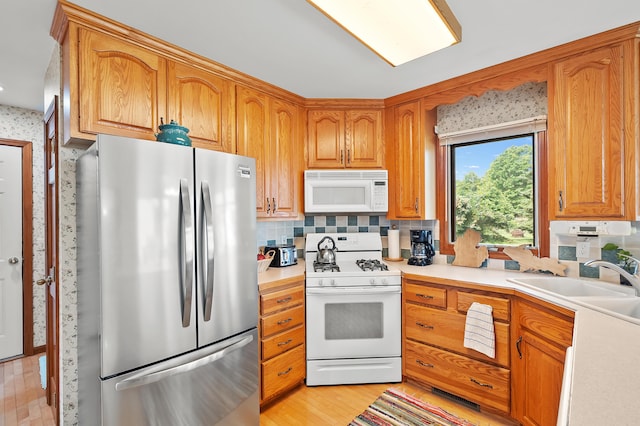 64670 Windrose Way, Lawton, MI 49065 - kitchen featuring white appliances, light countertops, decorative backsplash, light wood-type flooring, and brown cabinetry
