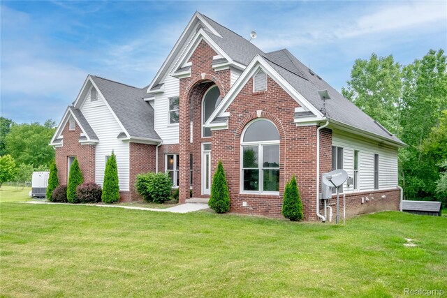 12462 Lillie Rd, Byron, MI 48418 - traditional-style house with brick siding, a front yard, and roof with shingles