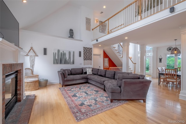 12462 Lillie Rd, Byron, MI 48418 - living room featuring a fireplace, stairway, a towering ceiling, and hardwood / wood-style floors