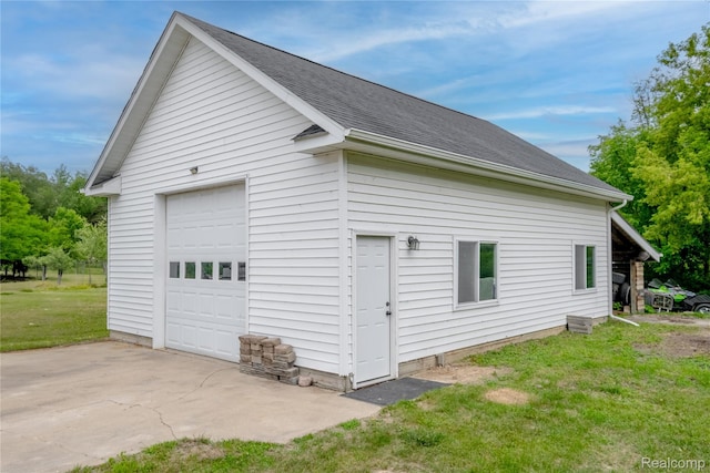 12462 Lillie Rd, Byron, MI 48418 - view of property exterior featuring a detached garage, an outbuilding, a lawn, and a shingled roof