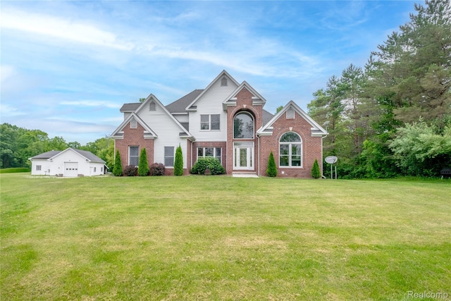 12462 Lillie Rd, Byron, MI 48418 - traditional home featuring brick siding, a front lawn, and a detached garage