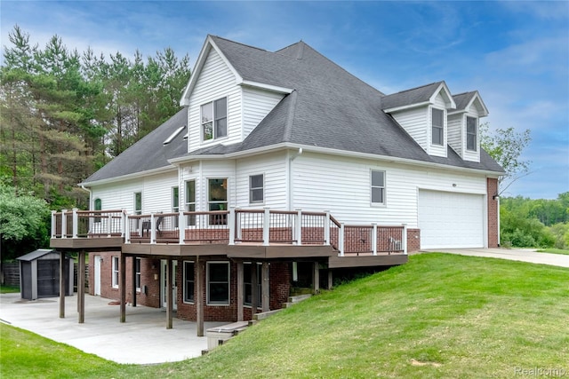 12462 Lillie Rd, Byron, MI 48418 - rear view of house featuring a wooden deck, a yard, brick siding, and a garage
