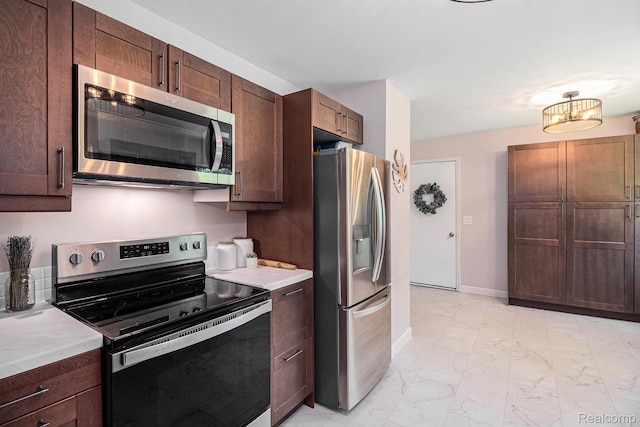 7440 Grandwood Dr, Swartz Creek, MI 48473 - kitchen with stainless steel appliances, light marble finish flooring, light countertops, and dark brown cabinets