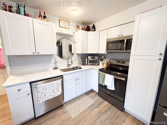 474 Argyle Cres, Milan, MI 48160 - kitchen featuring stainless steel appliances, light wood finished floors, light countertops, and white cabinets