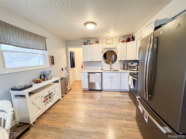 474 Argyle Cres, Milan, MI 48160 - kitchen with stainless steel appliances, light countertops, light wood finished floors, and white cabinetry