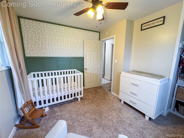 474 Argyle Cres, Milan, MI 48160 - carpeted bedroom with a nursery area, ceiling fan, and a decorative wall