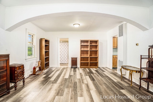 1124 Kusterer Dr NW, Grand Rapids, MI 49534 - sitting room featuring wood finished floors, arched walkways, a heating unit, and crown molding