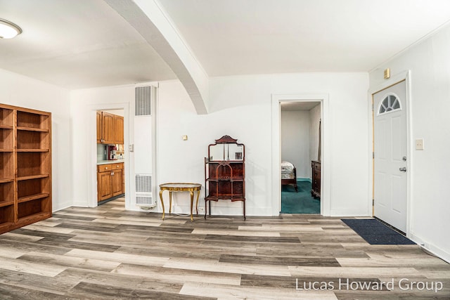 1124 Kusterer Dr NW, Grand Rapids, MI 49534 - entrance foyer with a heating unit, light wood-style flooring, arched walkways, and ornamental molding