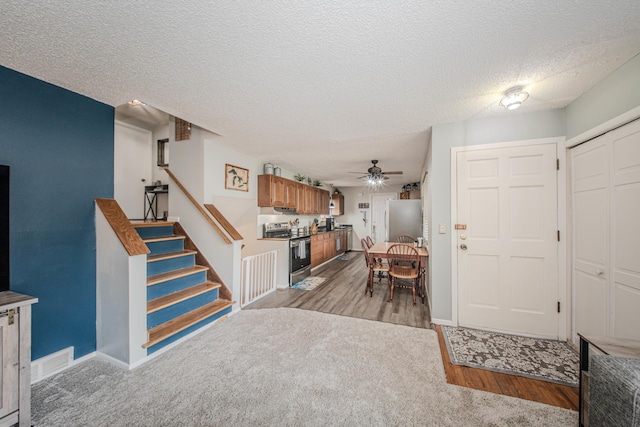 1361 Holmes Rd, Ypsilanti, MI 48198 - entryway with ceiling fan, stairway, light wood-style floors, and a textured ceiling