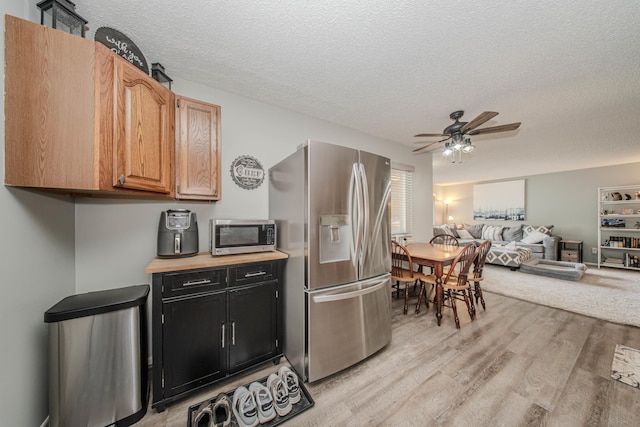 1361 Holmes Rd, Ypsilanti, MI 48198 - kitchen with stainless steel appliances, a textured ceiling, light wood-style floors, a ceiling fan, and dark cabinets