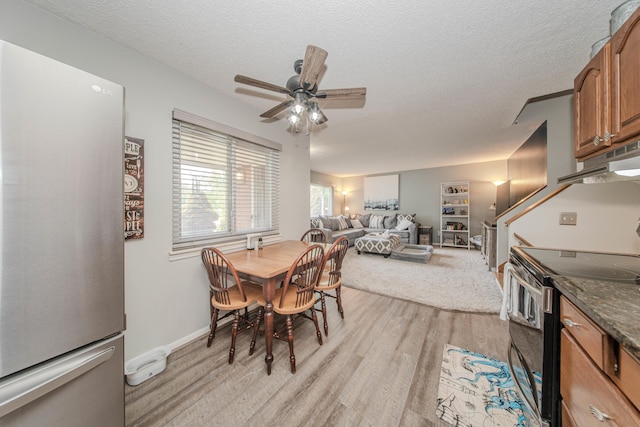 1361 Holmes Rd, Ypsilanti, MI 48198 - dining room with light wood-style flooring, a ceiling fan, and a textured ceiling