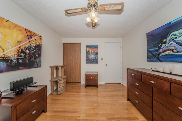 1361 Holmes Rd, Ypsilanti, MI 48198 - bedroom featuring light wood-style floors, ceiling fan, and a textured ceiling