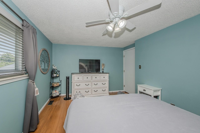 1361 Holmes Rd, Ypsilanti, MI 48198 - bedroom featuring light wood-style flooring, a textured ceiling, and a ceiling fan