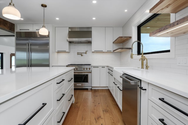 7280 Austin Rd, Saline, MI 48176 - kitchen with high quality appliances, wall chimney range hood, open shelves, tasteful backsplash, and recessed lighting