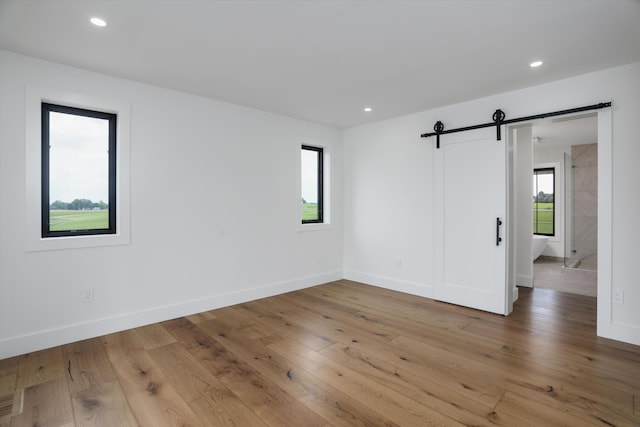 7280 Austin Rd, Saline, MI 48176 - spare room with a barn door, light wood finished floors, and recessed lighting