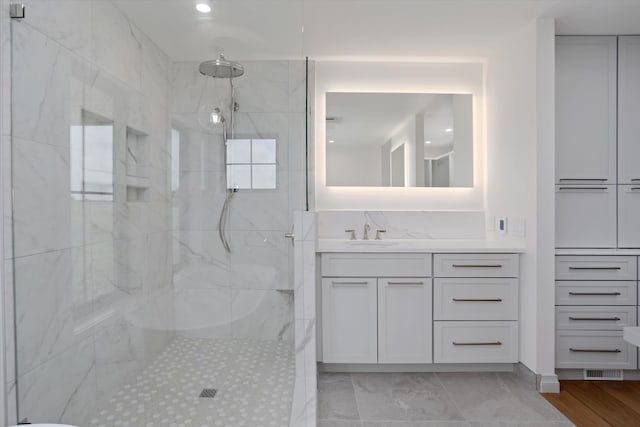 7280 Austin Rd, Saline, MI 48176 - bathroom featuring a marble finish shower, vanity, marble look tiles, and recessed lighting