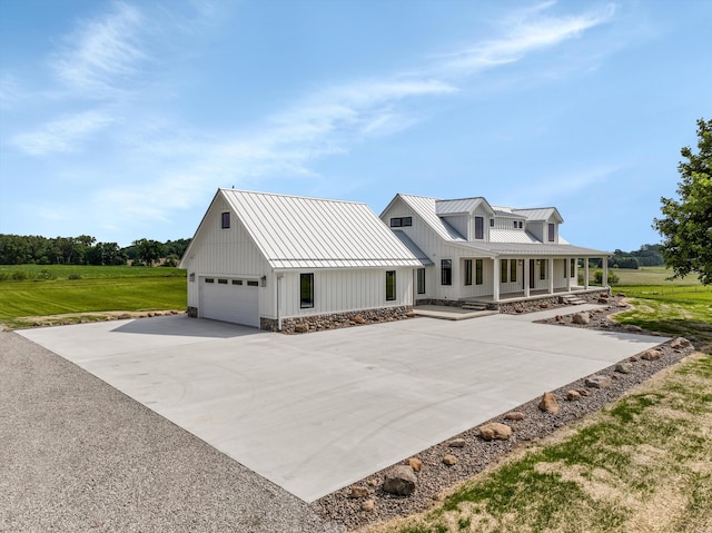 7280 Austin Rd, Saline, MI 48176 - view of front of home featuring a metal roof, a garage, a standing seam roof, and covered porch