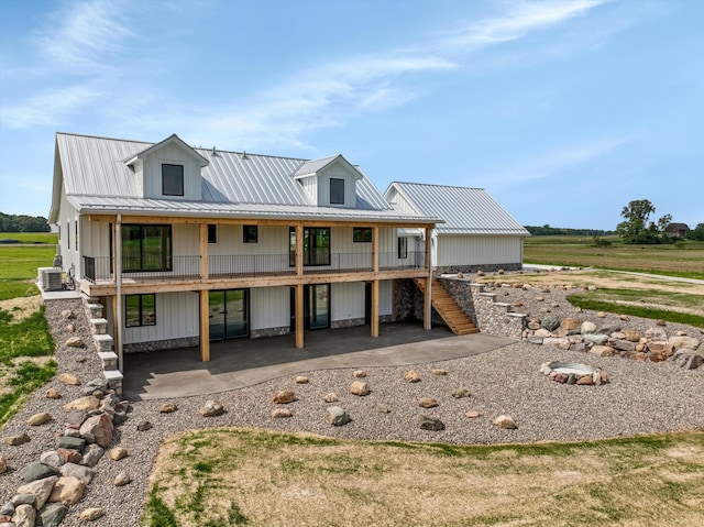 7280 Austin Rd, Saline, MI 48176 - view of front of property featuring stairs, a metal roof, a patio, and board and batten siding