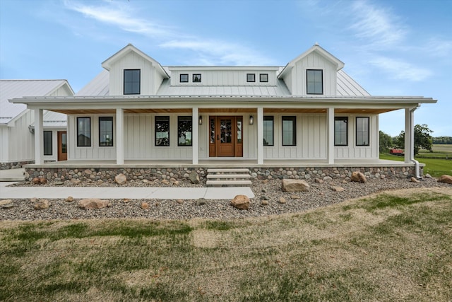 7280 Austin Rd, Saline, MI 48176 - modern farmhouse featuring board and batten siding, covered porch, a metal roof, and a front lawn