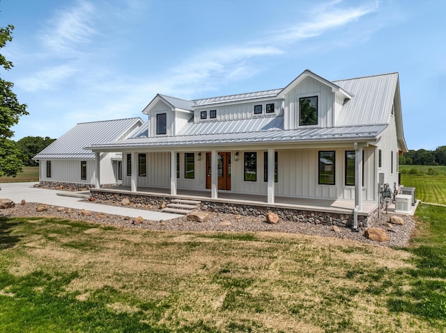 7280 Austin Rd, Saline, MI 48176 - modern inspired farmhouse with board and batten siding, a front yard, covered porch, and a metal roof