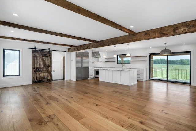 7280 Austin Rd, Saline, MI 48176 - unfurnished living room with a barn door, light wood-type flooring, beamed ceiling, and recessed lighting