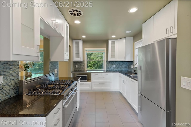 3603 Dukeshire Hwy, Royal Oak, MI 48073 - kitchen featuring appliances with stainless steel finishes, backsplash, glass insert cabinets, light tile patterned floors, and white cabinets