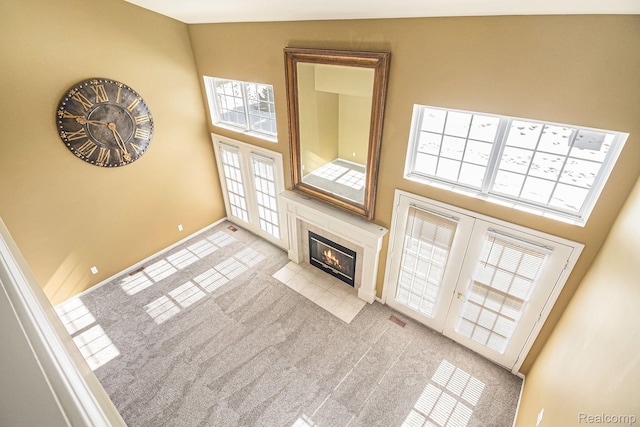 6438 Club Ct W, Grand Blanc, MI 48439 - unfurnished living room with a towering ceiling, a tiled fireplace, and light carpet