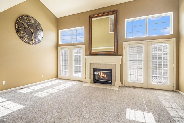 6438 Club Ct W, Grand Blanc, MI 48439 - unfurnished living room with french doors, carpet flooring, a tiled fireplace, plenty of natural light, and a high ceiling