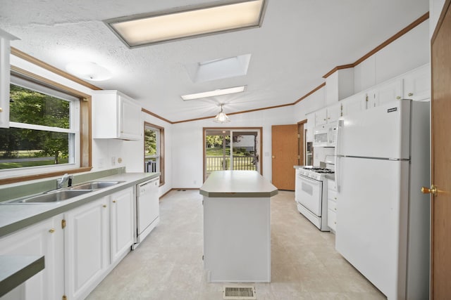 3280 Carlton Blvd, Jackson, MI 49203 - kitchen featuring white appliances, a center island, white cabinetry, a skylight, and ornamental molding
