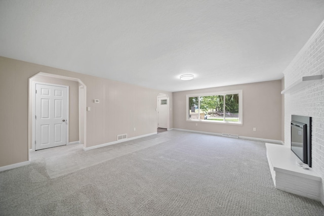 10620 Cady Rd, Jackson, MI 49201 - unfurnished living room featuring a fireplace, light carpet, and arched walkways