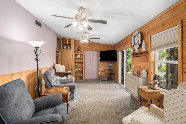 8828 Elm, Fremont, MI 49412 - carpeted living room featuring wood walls, vaulted ceiling, a ceiling fan, and radiator heating unit