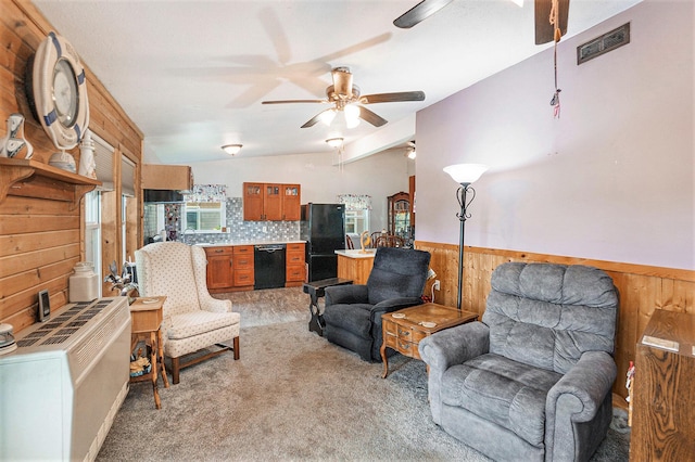 8828 Elm, Fremont, MI 49412 - living area with ceiling fan, wood walls, light colored carpet, vaulted ceiling, and a wainscoted wall