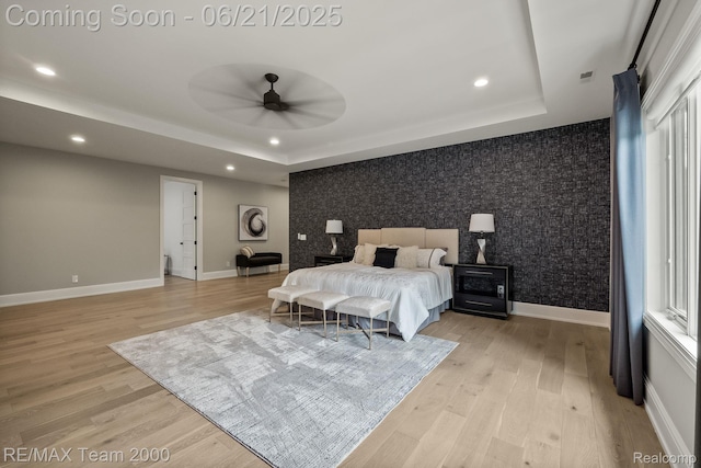 32575 Romsey Rd, Franklin, MI 48025 - bedroom featuring an accent wall, recessed lighting, a tray ceiling, light wood-style floors, and wallpapered walls