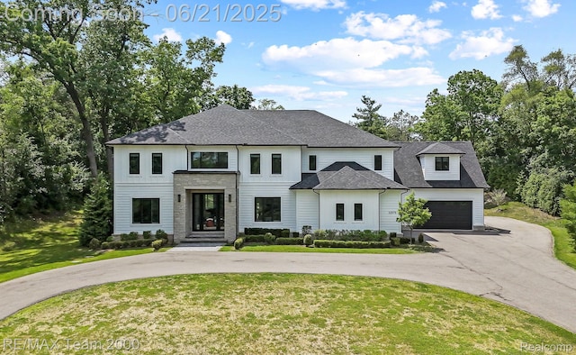32575 Romsey Rd, Franklin, MI 48025 - view of front of home featuring curved driveway, a front lawn, roof with shingles, and stone siding