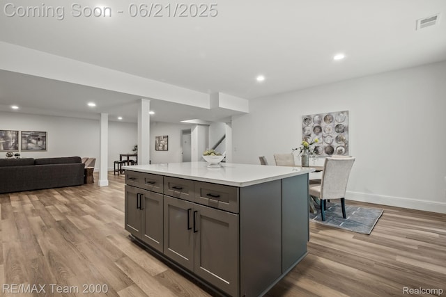 32575 Romsey Rd, Franklin, MI 48025 - kitchen featuring light wood-type flooring, gray cabinetry, light countertops, a kitchen island, and recessed lighting