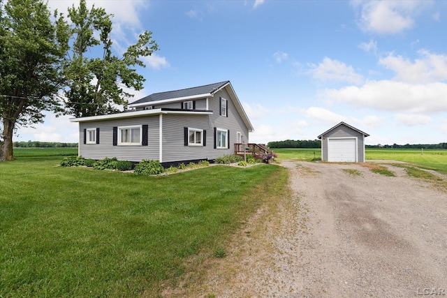 14211 Gilbert Rd, Waldron, MI 49288 - view of front facade with an outbuilding, dirt driveway, a front lawn, a garage, and a rural view