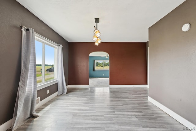 14211 Gilbert Rd, Waldron, MI 49288 - unfurnished dining area featuring arched walkways and wood finished floors