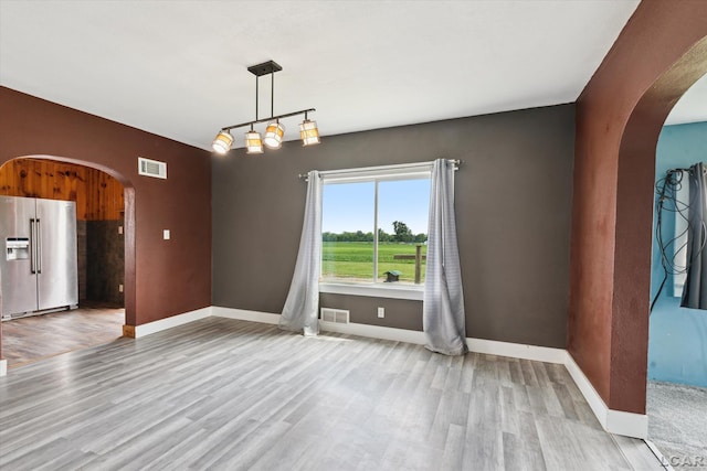 14211 Gilbert Rd, Waldron, MI 49288 - unfurnished dining area with arched walkways and wood finished floors