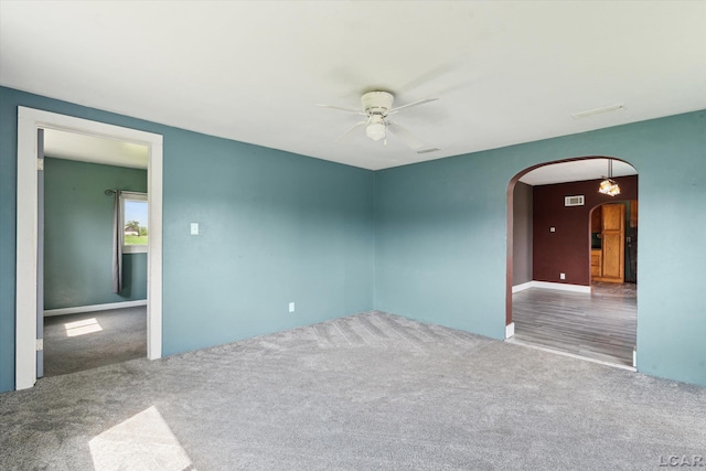 14211 Gilbert Rd, Waldron, MI 49288 - carpeted empty room with a ceiling fan and arched walkways