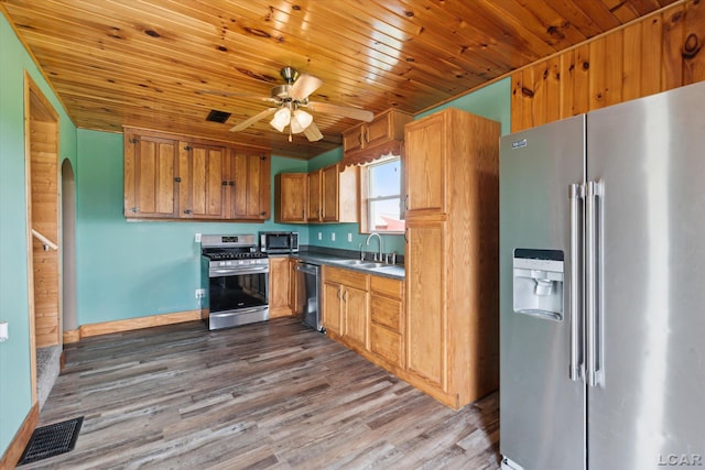 14211 Gilbert Rd, Waldron, MI 49288 - kitchen featuring appliances with stainless steel finishes, dark wood finished floors, ceiling fan, wood ceiling, and brown cabinetry