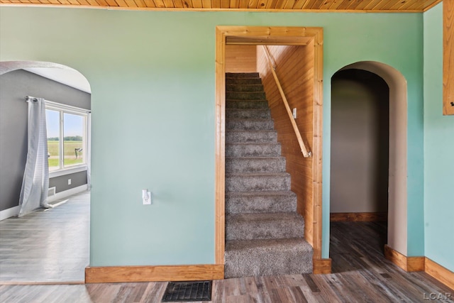 14211 Gilbert Rd, Waldron, MI 49288 - stairway with arched walkways, wood finished floors, and wood ceiling