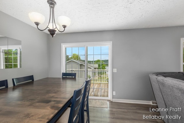 127 Hamilton Ln, Dowling, MI 49050 - dining space featuring wood finished floors, a textured ceiling, and a chandelier