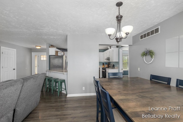 127 Hamilton Ln, Dowling, MI 49050 - dining room featuring dark wood-style flooring, a chandelier, and a textured ceiling
